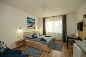 a bedroom with a bed and a couch and a television at Riverside Apartmanház Gyula in Gyula