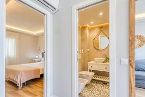 a bedroom with a bed and a sink and a mirror at Hanami Avenida de España La Gaviota in Estepona +17 photos