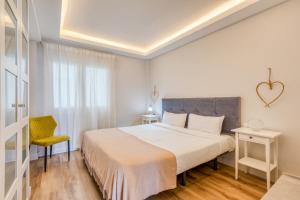 a bedroom with a large bed and a yellow chair at Hanami Avenida de España La Gaviota in Estepona