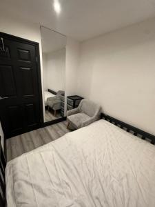 a bedroom with a bed and a mirror and a chair at Four Bedrooms and Two Bathrooms up to Nine People in Birmingham