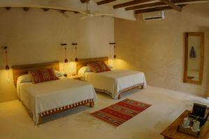 En eller flere senger på et rom på Hotel Poc Na Tulum