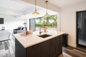 a kitchen with a sink and a living room at Host & Stay - The Stable in Dalbury Lees +12 photos
