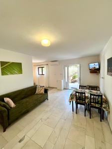 a living room with a green couch and a table at Apartments Martina 2 in Primošten