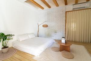 a bedroom with a white bed and a table at 19bnb獨立小屋 in Xiaoliuqiu