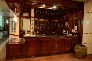 a bar with wooden cabinets and a counter in a room at Hotel Villa Tasko in Drama