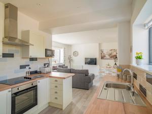 an open kitchen and living room with a couch at Stunning modern apartment in the Cotswolds 55 minute drive to Bath Christmas market in Chalford