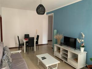 a living room with a couch and a tv and a table at Vannimar t2 in Porto Novo