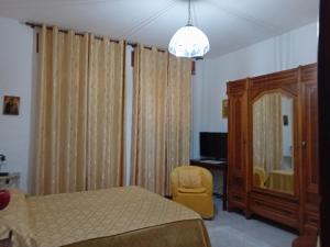 a bedroom with a bed and a chair and a mirror at B&B il Girasole in Corridonia