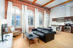 ケベック・シティーにあるレイ ロフト 1048の黒い革張りのソファと窓のあるリビングルーム