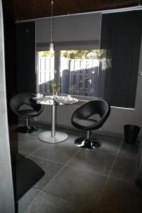 une chambre avec deux chaises noires et une table dans l'établissement Studios Jps, à Les Flaches