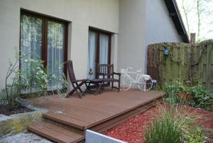 una terraza de madera con una silla y una bicicleta. en Studios Jps, en Les Flaches