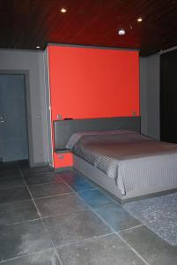 sypialnia z łóżkiem z czerwoną ścianą w obiekcie Studios Jps w mieście Les Flaches