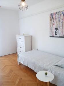 a white bedroom with a bed and a table at Apartman Nela Banjole in Banjole