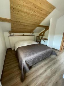 ein Bett in einem Zimmer mit Holzdecke in der Unterkunft Gîte 5 personnes in Le Bonhomme