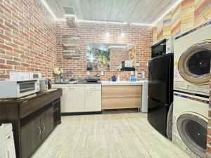 a kitchen with a washer and a brick wall at New open Hotel Jungle fun fun J4 USJ 8minutes nishikujyo 3minutes in Osaka +35 photos