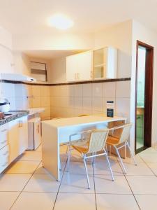 a kitchen with a table and two chairs in it at TerrazzoPontaNegraDJ in Natal