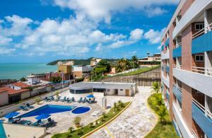 a view of a building with a swimming pool and the ocean at TerrazzoPontaNegraDJ in Natal