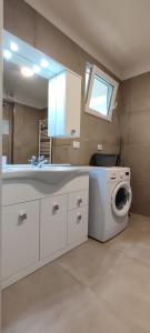 a bathroom with a washing machine and a sink at Erica in Folgaria