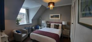 a hotel room with a bed and a chair at Rocklea Guest House in Windermere