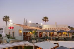 a large white building with palm trees in the background at Vale Do Lobo Resort in Vale do Lobo