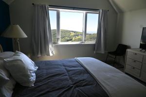 a bedroom with a bed with a large window at Panoramic Ski Slope Views, private sauna, dogs ok in Wintergreen