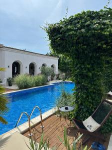 a house with a swimming pool and a patio with chairs at Elia Vama Veche (Adults Only) in Vama Veche