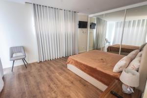 ein kleines Schlafzimmer mit einem Bett und einem Spiegel in der Unterkunft Casa do Beco do Barlavento in Vila Baleira