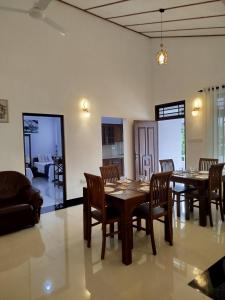 a dining room with a wooden table and chairs at Cosy White Palace in Negombo
