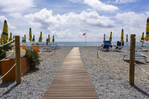 a pathway on a beach with chairs and umbrellas at Trilocale vista spiaggiamare in Diano Marina