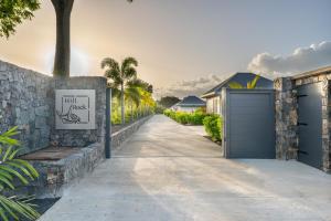 a driveway with a stone wall and a garage at Hill Rock villas - Blue Silver in Petit-Bourg