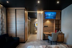 a room with a desk and a television on a wall at Turul Boutique Rooms & Apartment in Szarvas