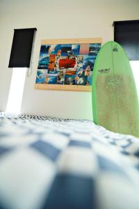 a green surfboard sitting on top of a table at Surf House in Aljezur
