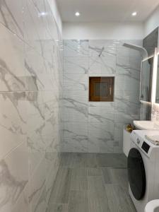 a bathroom with a sink and a washing machine at Milmar in Draga Bašćanska +19 photos