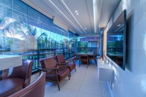 a restaurant with a table and chairs and a large window at Mandara Lanai Apartamento Bangalô in Aquiraz