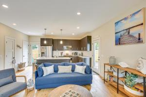 a living room with a blue couch and a kitchen at Traverse City Townhome Walk to Boardman Lake! in Traverse City