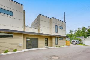 a house with a yellow and white facade at Traverse City Townhome Walk to Boardman Lake! in Traverse City