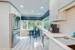 a kitchen with white cabinets and a table with stools at Fieldcrest in Brevard