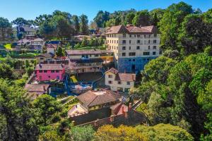 a group of houses on a hill with a building at VELINN Hotel Ninho do Falcão in Monte Verde