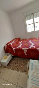 a bed in a room with a window and a bed sidx sidx sidx at Appartement Plage et Bien-être in Fnidek +5 photos