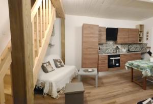 a small room with a staircase and a kitchen at Le CHRISOL in Le Chambon-sur-Lignon