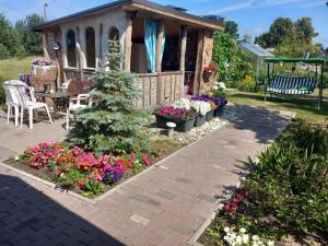 a flower garden in front of a gazebo at Saulespuķe in Ventspils