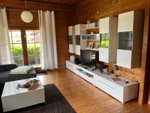 a living room with white cabinets and wooden walls at Blockhaus FerienZauber II in Bromskirchen