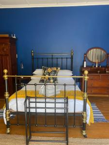 a bedroom with a bed with a blue wall at Arendsnest in Springbok