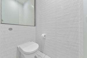 a white bathroom with a toilet and a mirror at Central London Spectacular riverview two bedroom Luxury designer apartment-AC-Parking-WIFI-2 bathrooms in London +42 photos