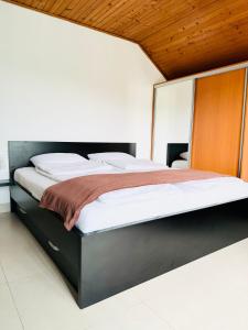 a bedroom with a large bed with a wooden headboard at Apartman HAN in Sarajevo
