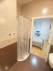 a bathroom with a shower curtain and a bed at Hostal Fabiola in Seville +47 photos