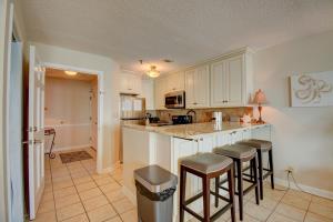 a kitchen with white cabinets and bar stools at Villa Capriani 315B in Chadwick Acres +34 photos