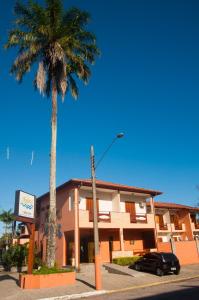 
a palm tree stands in front of a building at Pousada Mar Azul in Ubatuba
