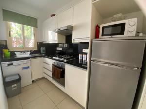 a kitchen with a refrigerator and a microwave at Elysia Park Grand Spa & Wellness Apartment up to 7 guests in Paphos City