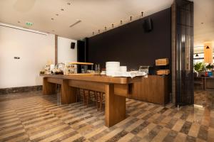 a kitchen with a long wooden counter with chairs at Infinity Hotel & More in Budva
